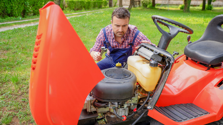 Man working on riding lawn mower engine