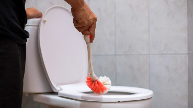 A man cleaning his toilet