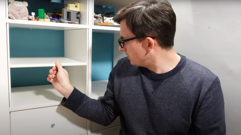 Person installing white IKEA Kallax shelf dividers