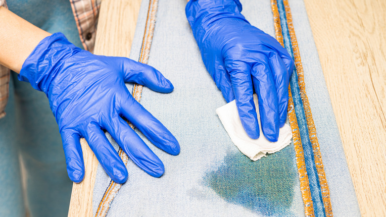 Woman's hands blotting stains on jeans