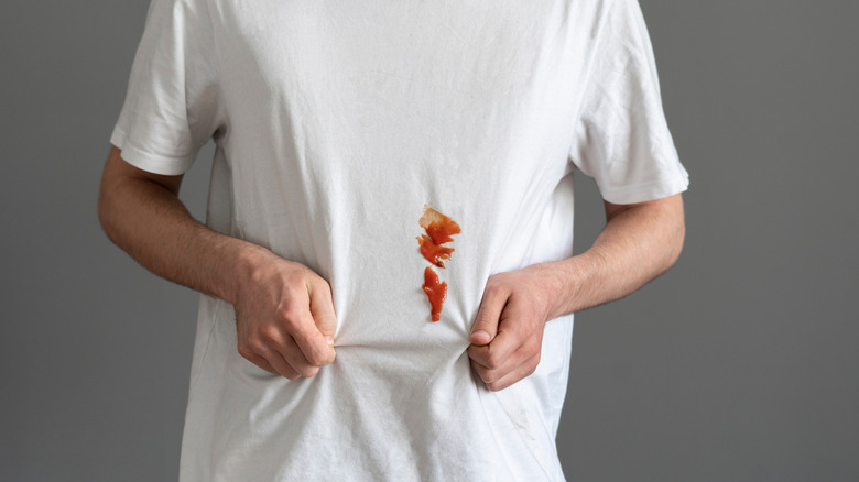 Ketchup stain on a man's white t-shirt
