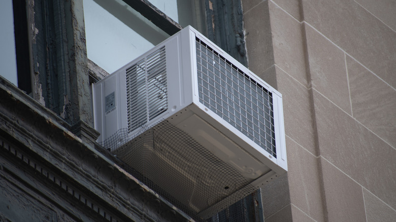 A window AC unit on an upper floor, seen from the outside of a building