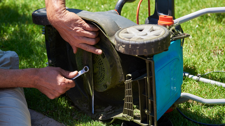 Worker. lawn mowers wait repair sharp knives grow and tighten.