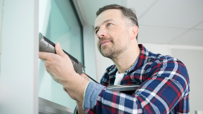 Person using caulking gun