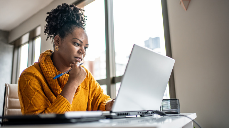 woman thoughtful on laptop