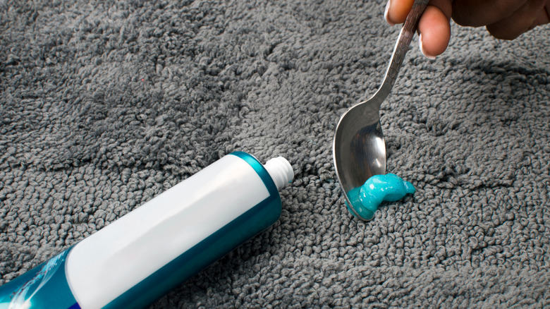 Spoon removing toothpaste from carpet