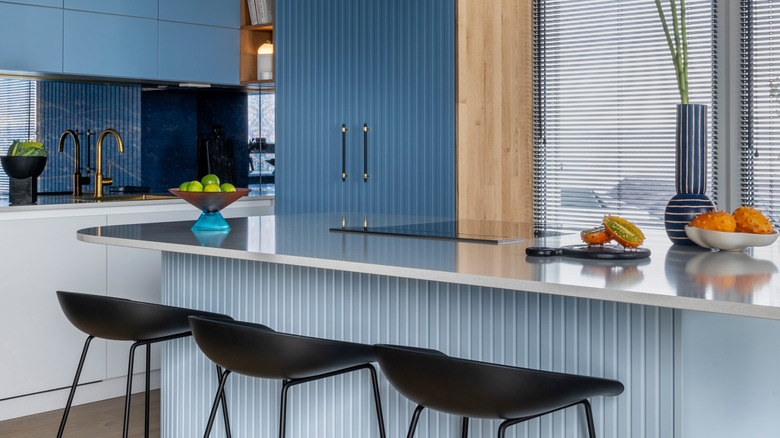 Kitchen with light blue island and medium blue cabinetry