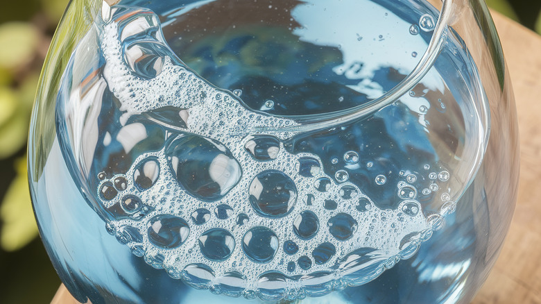 Soap bubbles on a background of blue water as a texture.