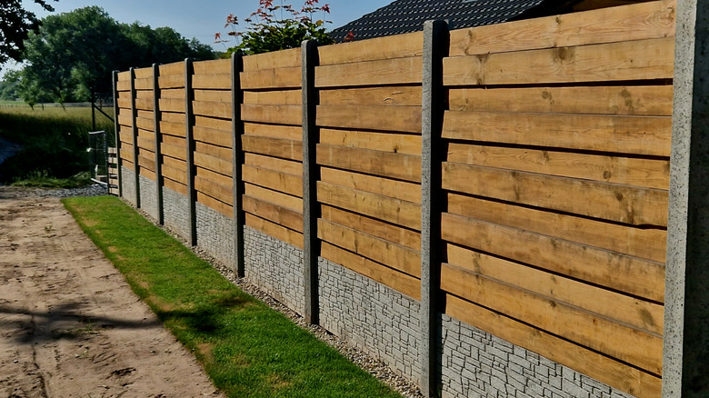 A wooden privacy fence with concrete base.