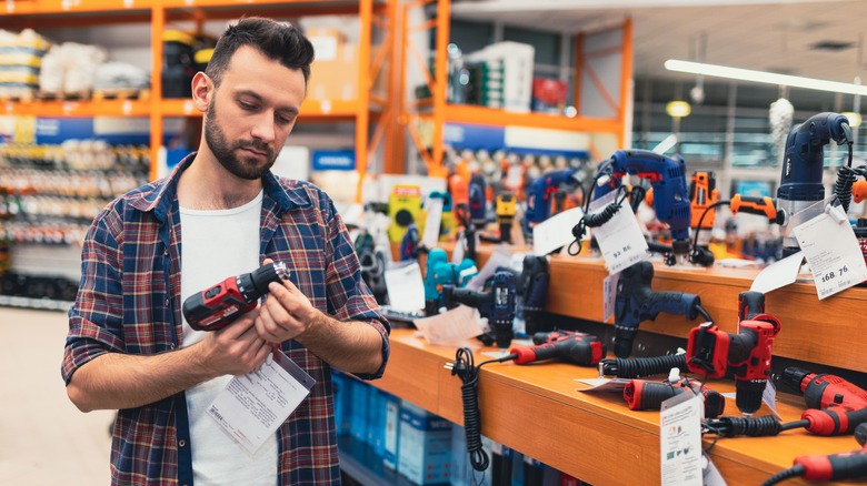 man checking prices on power tools