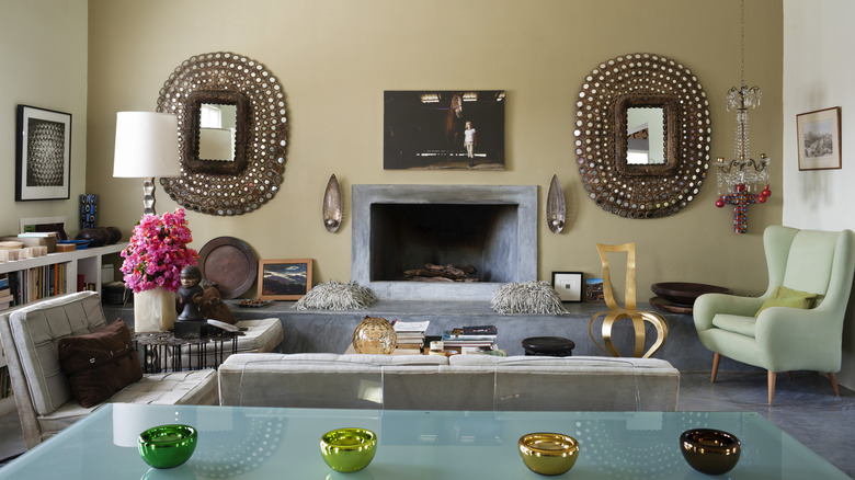 A fireplace framed by two ornate mirrors is a focal point for a living room.