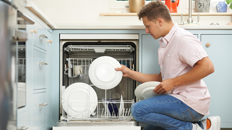 Man loading dishwasher