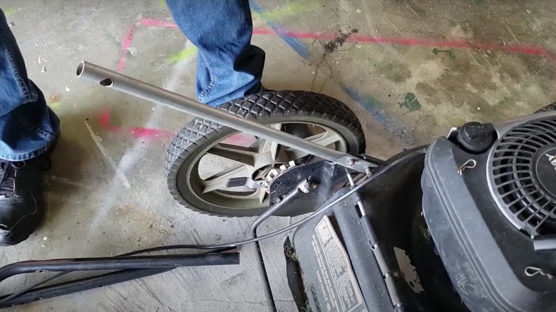 Content creator shows how to fix a broken lawn mower handle with pipe