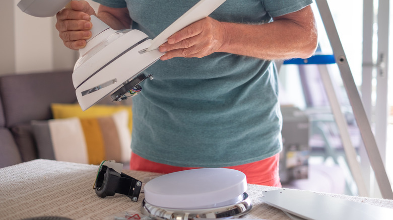 Man replacing blades on a ceiling fan