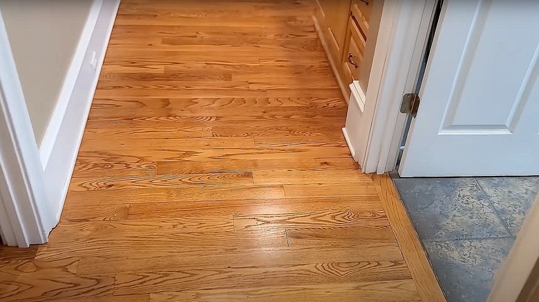 Person sweeping polished wood flooring