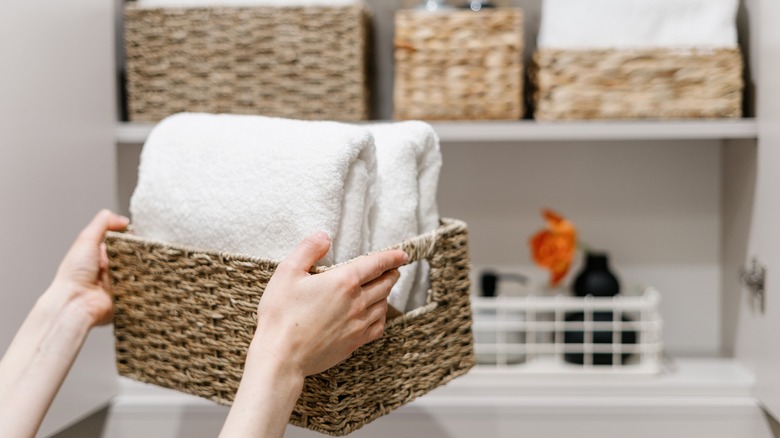 woman stores folded hand towels