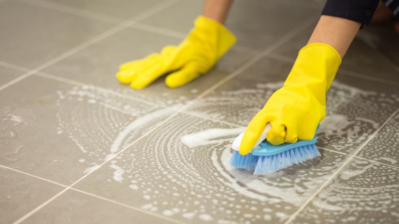 Person scrubbing tiled floors