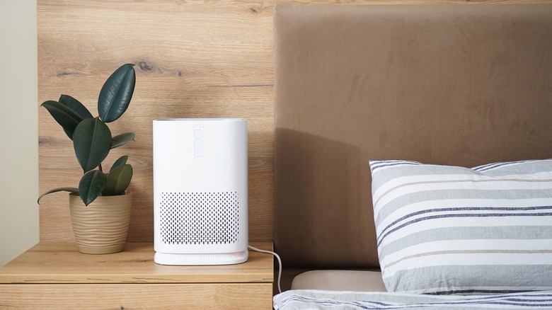 air purifier near wooden bed