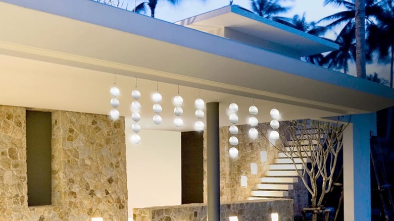 Hanging reflective disks along outdoor overhang to deter birds