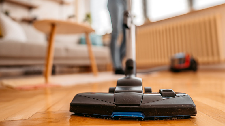 Person vacuuming parquet floor
