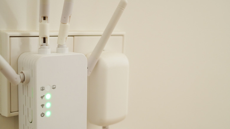 A white Wi-Fi extender plugged into the wall.