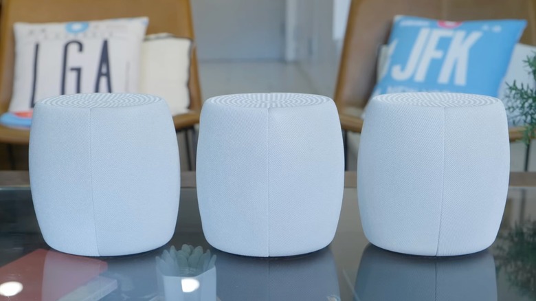 Three mesh network devices sitting on a table.