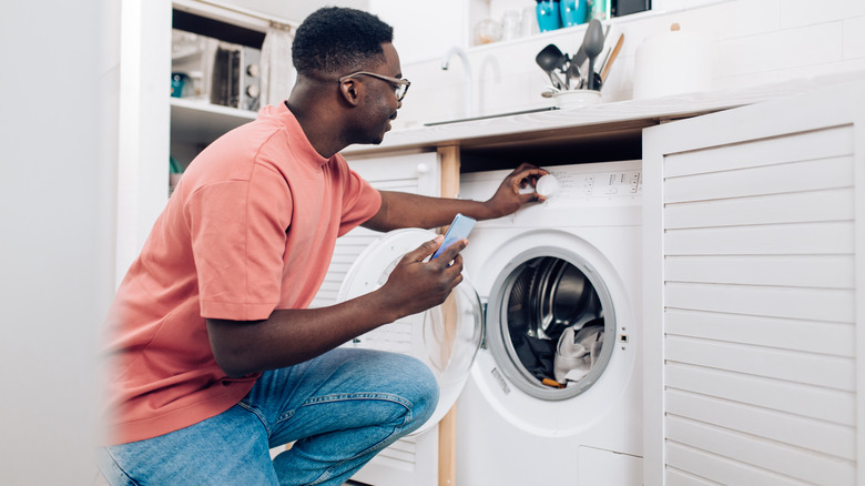 man turning on washing machine