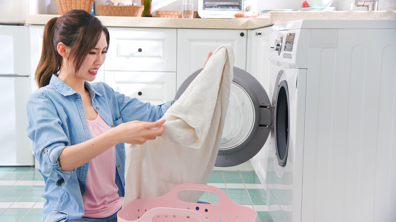 woman frowning at dirty laundry