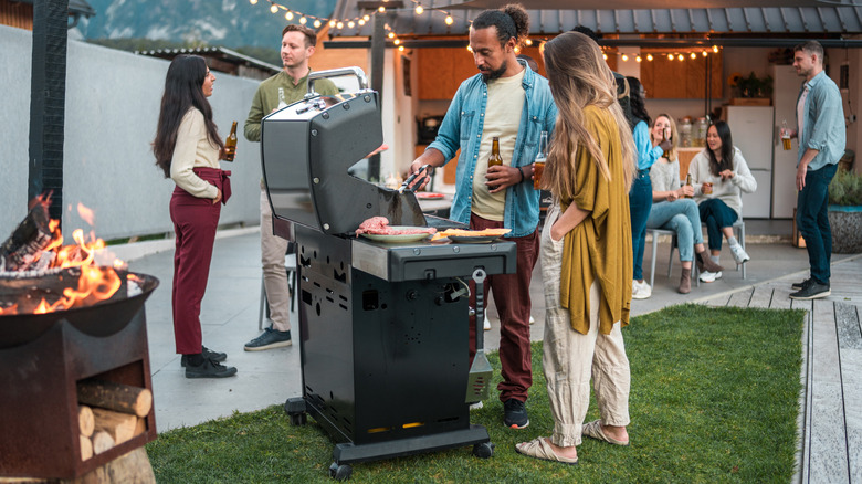 A group of friends grilling food on a summer's evening