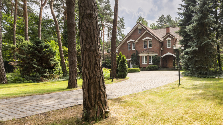 A large brick home with a long driveway.