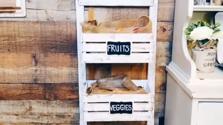 A white produce stand holding fruits and veggies.