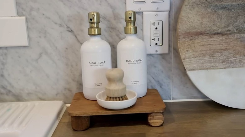 A DIY wooden tray holds sink essentials in the kitchen.