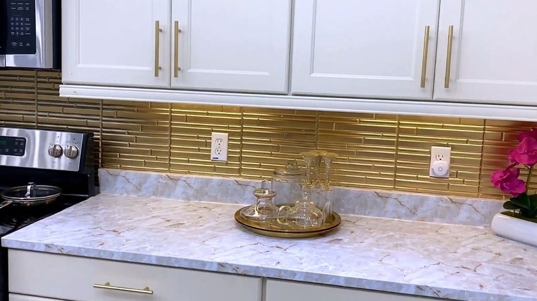 A high-end kitchen with a gold tile backsplash
