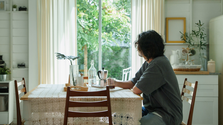 Someone sitting at the kitchen table looking out the window.
