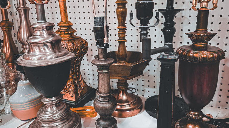 Several ornate lamp bases on a secondhand shop shelf