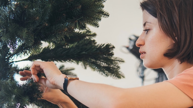 Person fluffing Christmas tree