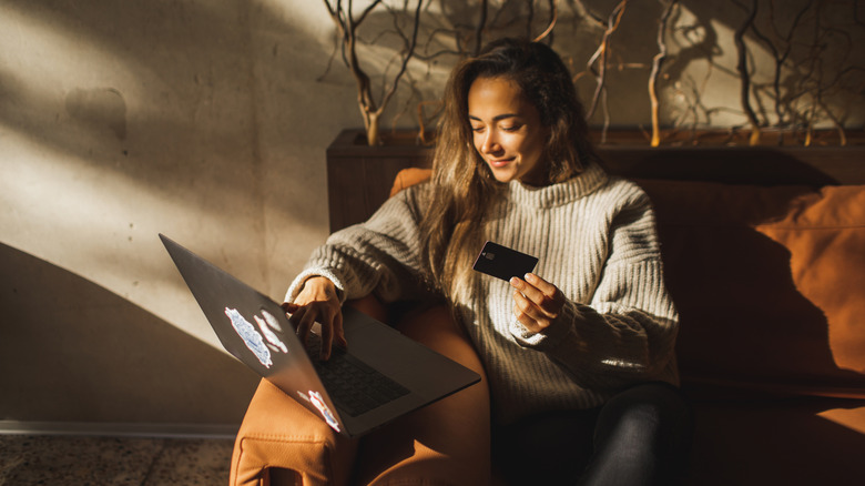 Woman holding credit card with laptop online shopping