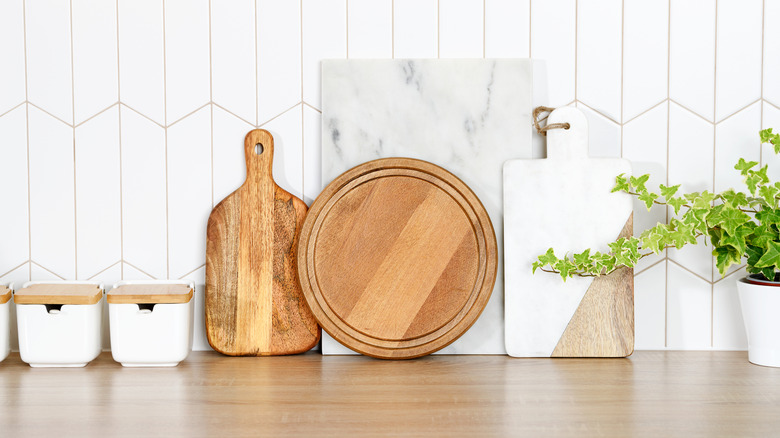 A collection of wooden and marble cutting boards on a countertop