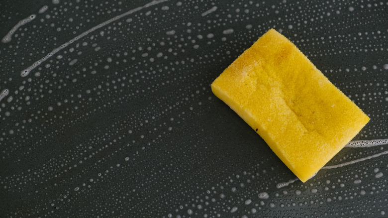 Using a sponge and dish soap to clean a surface