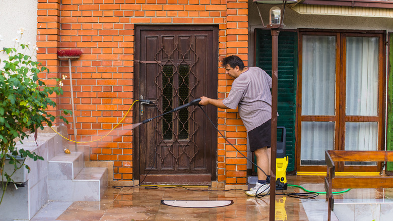 Someone pressure washing home