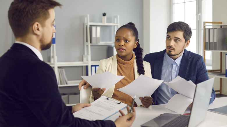 A worried couple talks to an attorney