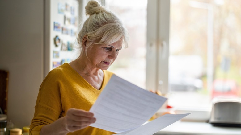 A serious looking woman reads paperwork