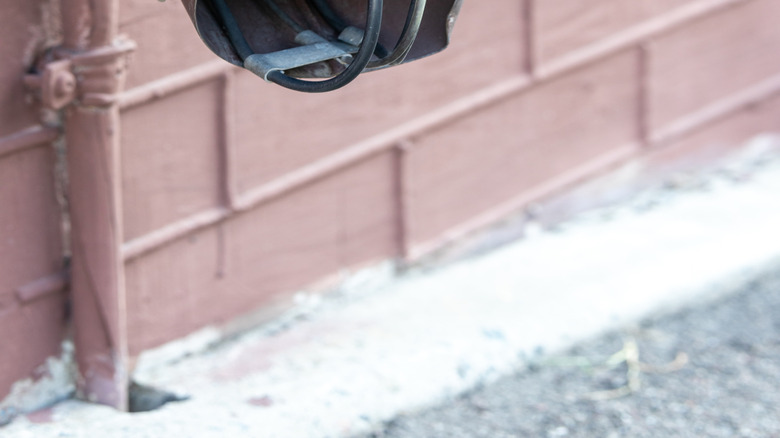 The base section of a gutter water drain has heat cables extending out of the hole.