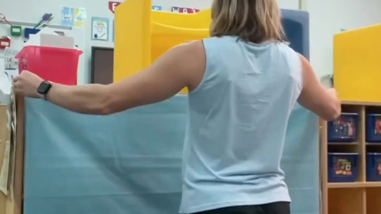 woman hanging fabric over shelves
