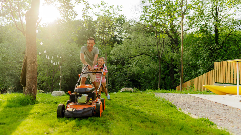 Father and son mow lawn
