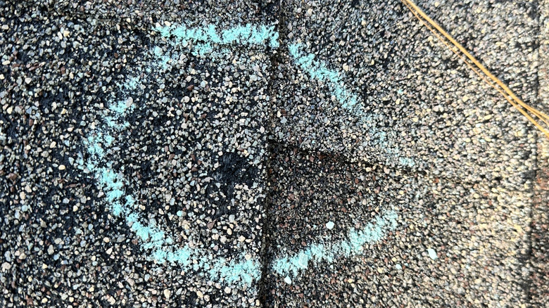 Hail damage on shingle with chalk circle around it