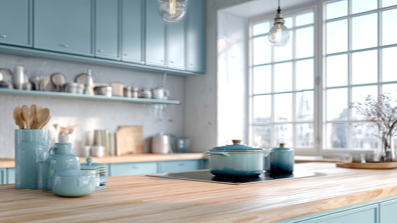 A kitchen with blue lower cabinets and white upper cabinets