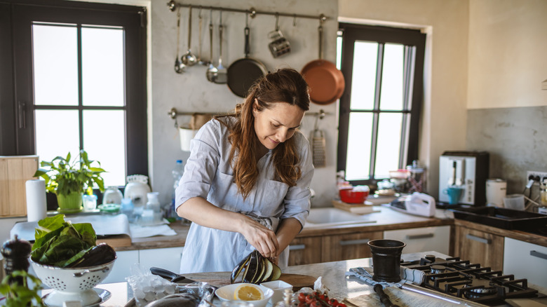 Mediterranean kitchen full of light with a woman in a light blue dress cooking