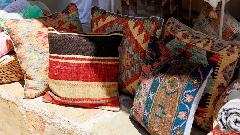 Pillows with colorful patterns on a stone bench