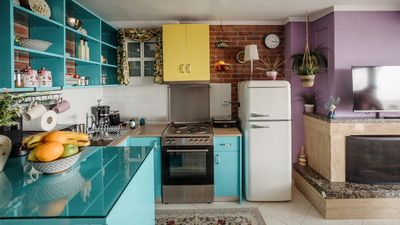 Vibrant kitchen with pops of blue, purple, and yellow walls and cabinetry.